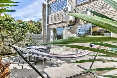 a hammock on the patio of a house at Silverview Modern Duplex Fully Air-Conditioned near Beach in Cape Town