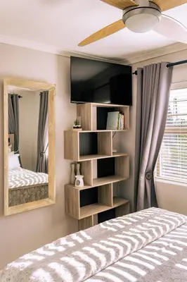 a bedroom with a bed and a mirror at Onrus Family Retreat in Hermanus