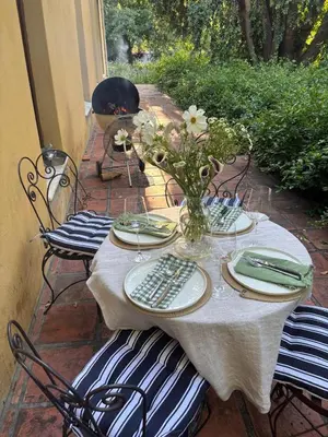 a table with plates and a vase of flowers on it at Die Jonkmanshuis in Stellenbosch
