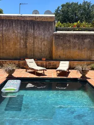 a swimming pool with two lounge chairs and a swimming pool at Die Jonkmanshuis in Stellenbosch