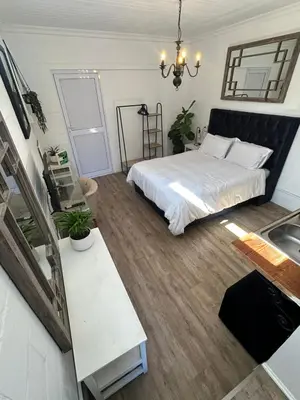 a bedroom with a bed and a sink in it at Studio Seabiscuit in Cape Town