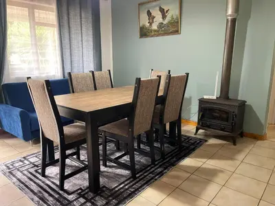 a dining room with a table and chairs and a wood stove at The Garden House in Hermanus