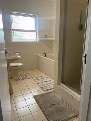 a bathroom with a shower and a toilet and a sink at The Garden House in Hermanus