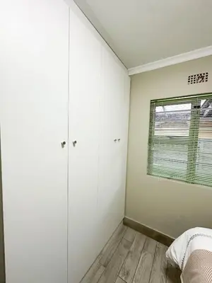 a bedroom with white cabinets and a window at 29 on Windsor-2 Bedroom House in Silver Sands