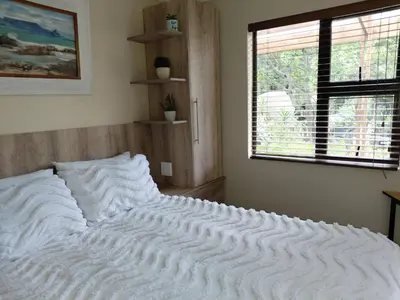 a large white bed in a room with a window at Place of Old D in Eersterivier