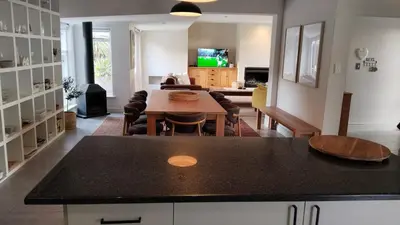 a kitchen and living room with a table and chairs at 6 on Krisant-Durbanville in Oakdale