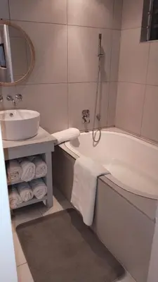 a bathroom with a sink and a bath tub next to a mirror at 6 on Krisant-Durbanville in Oakdale