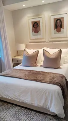 a bedroom with a large bed with white sheets and pillows at 6 on Krisant-Durbanville in Oakdale