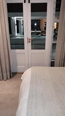 a bedroom with a bed and a door with windows at 6 on Krisant-Durbanville in Oakdale