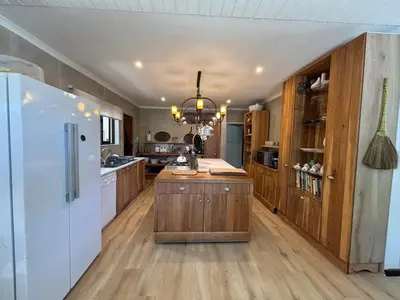 a kitchen with a white refrigerator and wooden cabinets at 4 Molteno in Hermanus