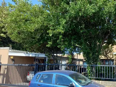 a blue car parked in front of a fence at A Stone's Throw away in Cape Town
