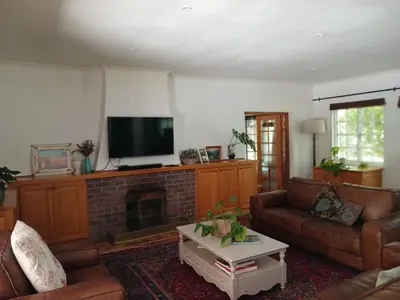 a living room with a couch and a fireplace at Spacious Family Home - Windsor Retreats in Somerset West