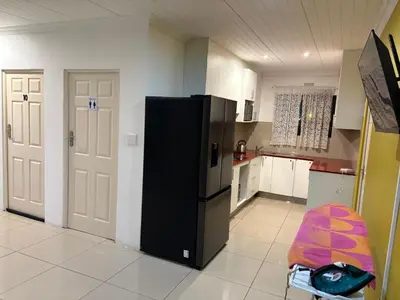 a kitchen with a black refrigerator and a st at SNE Travellers in Faure
