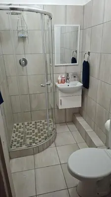 a bathroom with a shower and a toilet and a sink at MDA Myburgh in Brackenfell