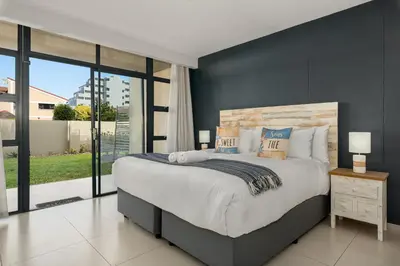 a bedroom with a large bed and a large window at La Cabina 105 in Cape Town