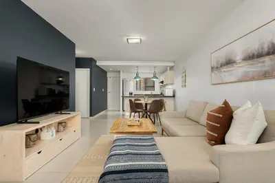 a living room with a couch and a table at La Cabina 105 in Cape Town