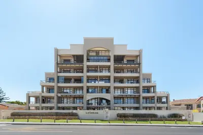 a large apartment building with balconies on a street at La Cabina 105 in Cape Town