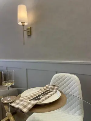 a glass table with a plate and a wine glass at Nomads Hermanus in Hermanus