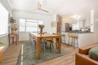 a dining room and kitchen with a table and chairs at 5 Bedroom Family Home with Private Apartment in Hermanus