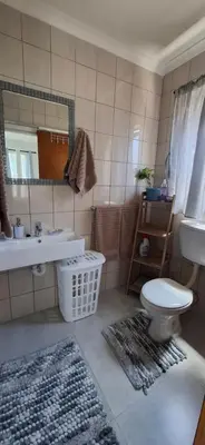 a bathroom with a sink and a toilet and a mirror at Grey Vine Cottage - Flatlet in Cape Town