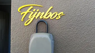 a suitcase on the floor next to a yellow sign at Fijnbos - Something-Els in Rooiels