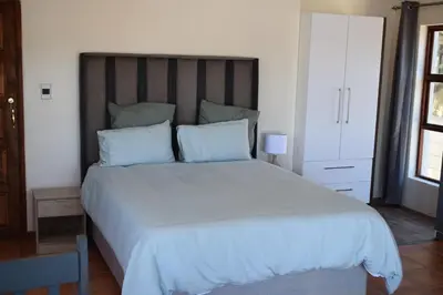 a bedroom with a large white bed with blue pillows at The Crest Studio in Oakdale