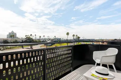 a balcony with two chairs and a view of the city at Nine Palms Stunning 1-Bedroom Apartment in Century City