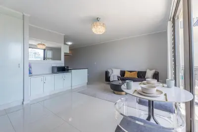 a kitchen and a living room with a table at St Tropez On Lake 302 The Island Club in Cape Town