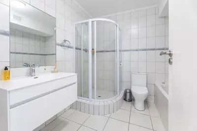 a bathroom with a shower and a sink and a toilet at St Tropez On Lake 302 The Island Club in Cape Town