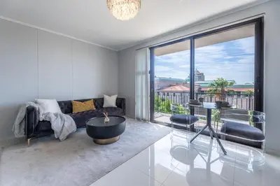 a living room with a couch and a table at St Tropez On Lake 302 The Island Club in Cape Town