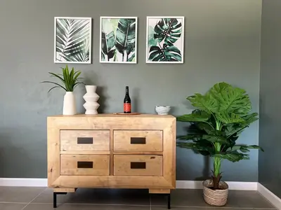 a wooden dresser with a bottle of wine and a plant at Rissie's Villa in Gordonʼs Bay