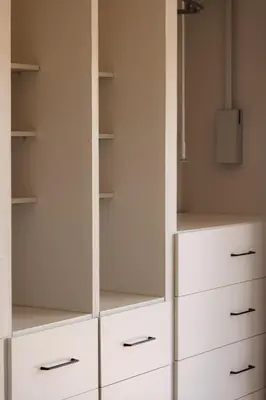 a closet with white cabinets and drawers at Rissie's Villa in Gordonʼs Bay
