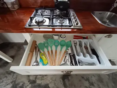 a drawer filled with cooking utensils next to a stove at 66onjennings Strand in Strand