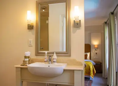 a bathroom with a white sink and a mirror at 5 Seasons Guest House in Stellenbosch
