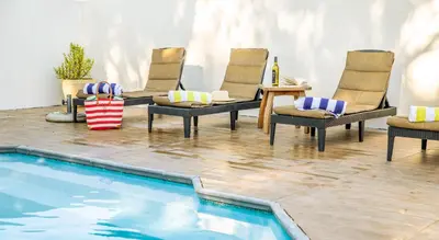 a patio with chairs and a swimming pool at Lovane Boutique Wine Estate and Guesthouse in Stellenbosch
