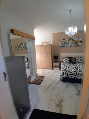 a living room with a bed and a chandelier at Livingsound 1bed self cat apartment in Cape Town