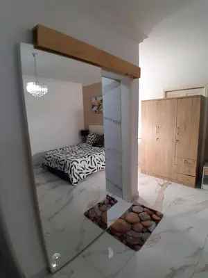 a reflection of a bedroom with a bed in a mirror at Livingsound 1bed self cat apartment in Cape Town
