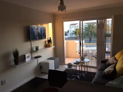 a living room with a couch and a table at 10 South Views in Bloubergstrand