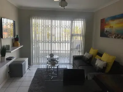 a living room with a couch and a table at 10 South Views in Bloubergstrand
