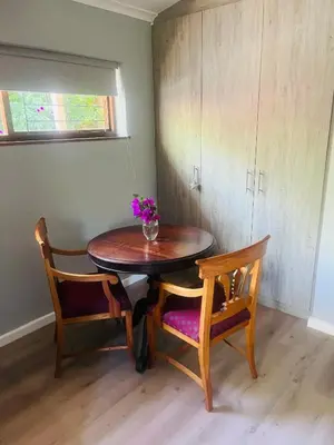 a table with two chairs and a vase with flowers on it at 41 on RUPERT in Helderberg