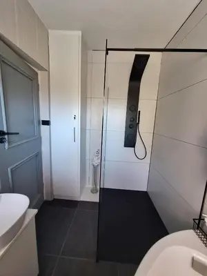 a shower with a glass door in a bathroom at 41 on RUPERT in Helderberg