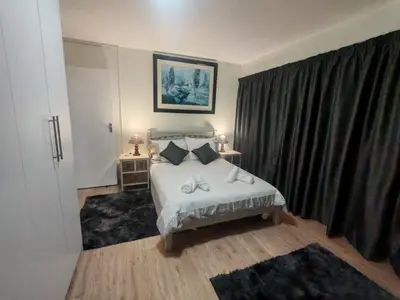 a bedroom with a bed and a large window at Central, Spacious GF Apartment, access to N1,N2,M5