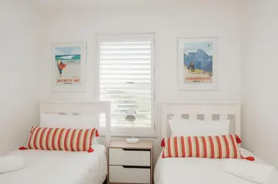 two white beds in a bedroom with a window at Hermanus Beach Club 218 in Hermanus