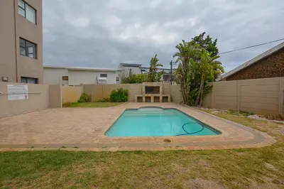 a swimming pool in the yard of a house at 3B Sandy Bay in Cape Town
