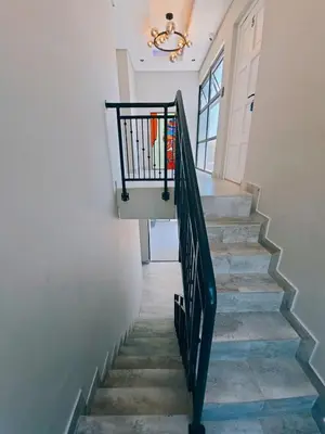 a stairway with a black railing and a stair case at Beach Walk Guest House & Apartments in Cape Town