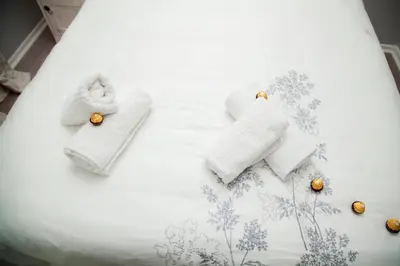 a white bed with towels and decorations on it at Divine Favor House on 44 Torrington in Cape Town