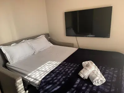 a bed with a cast on it with a television at Divine Favor House on 44 Torrington in Cape Town