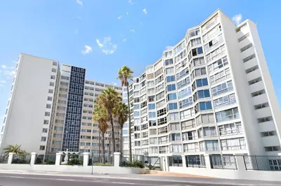 an image of a large apartment building with palm trees at 46 on Beach by Beach Collection Winelands in Strand