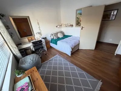a bedroom with a bed and a desk and a television at Family Home with Big Garden & Jacuzzi in Welgelegen