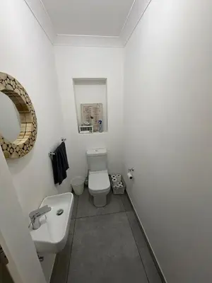 a white bathroom with a toilet and a sink at Family Home with Big Garden & Jacuzzi in Welgelegen